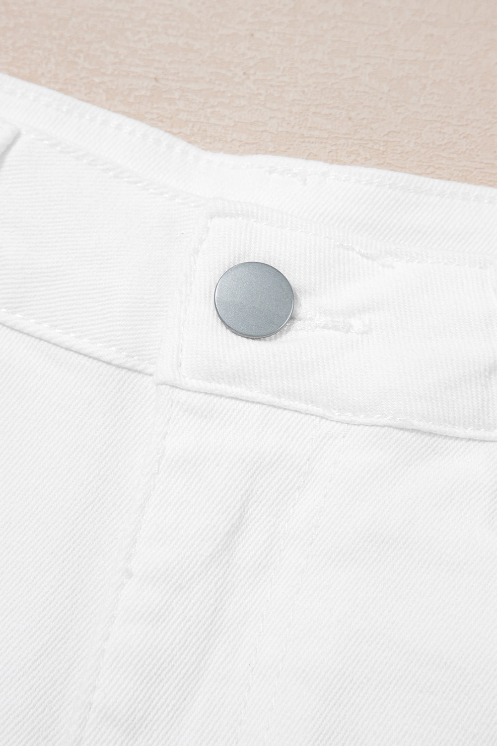 Shorts de denim blanco lavado claro con dobladillo ondulado