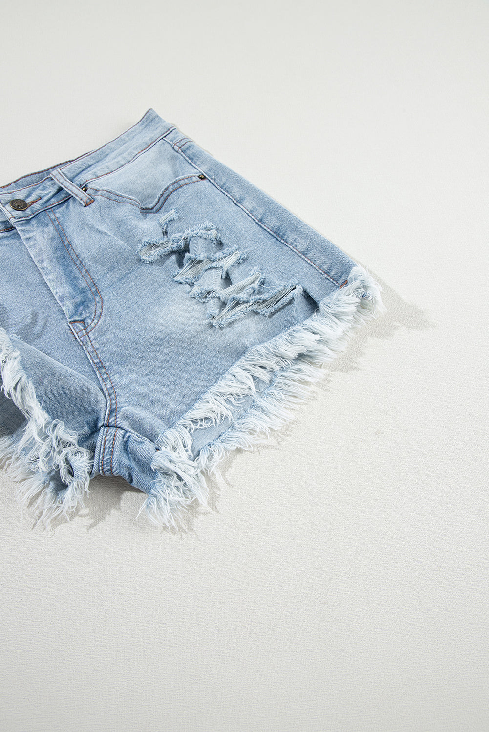 Shorts de denim azul claro desgastados con roturas, tiro alto y dobladillo crudo