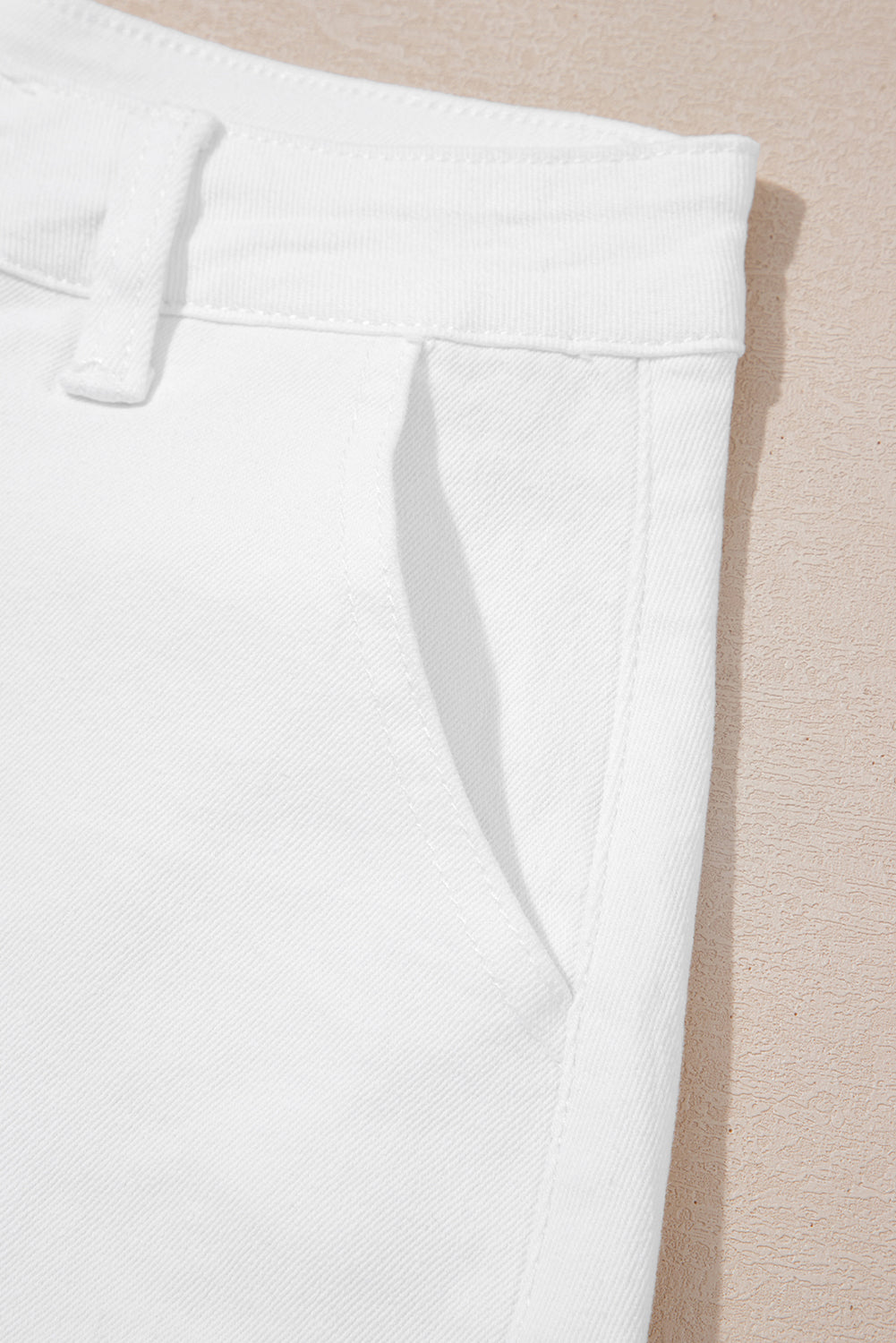 Shorts de denim blanco lavado claro con dobladillo ondulado