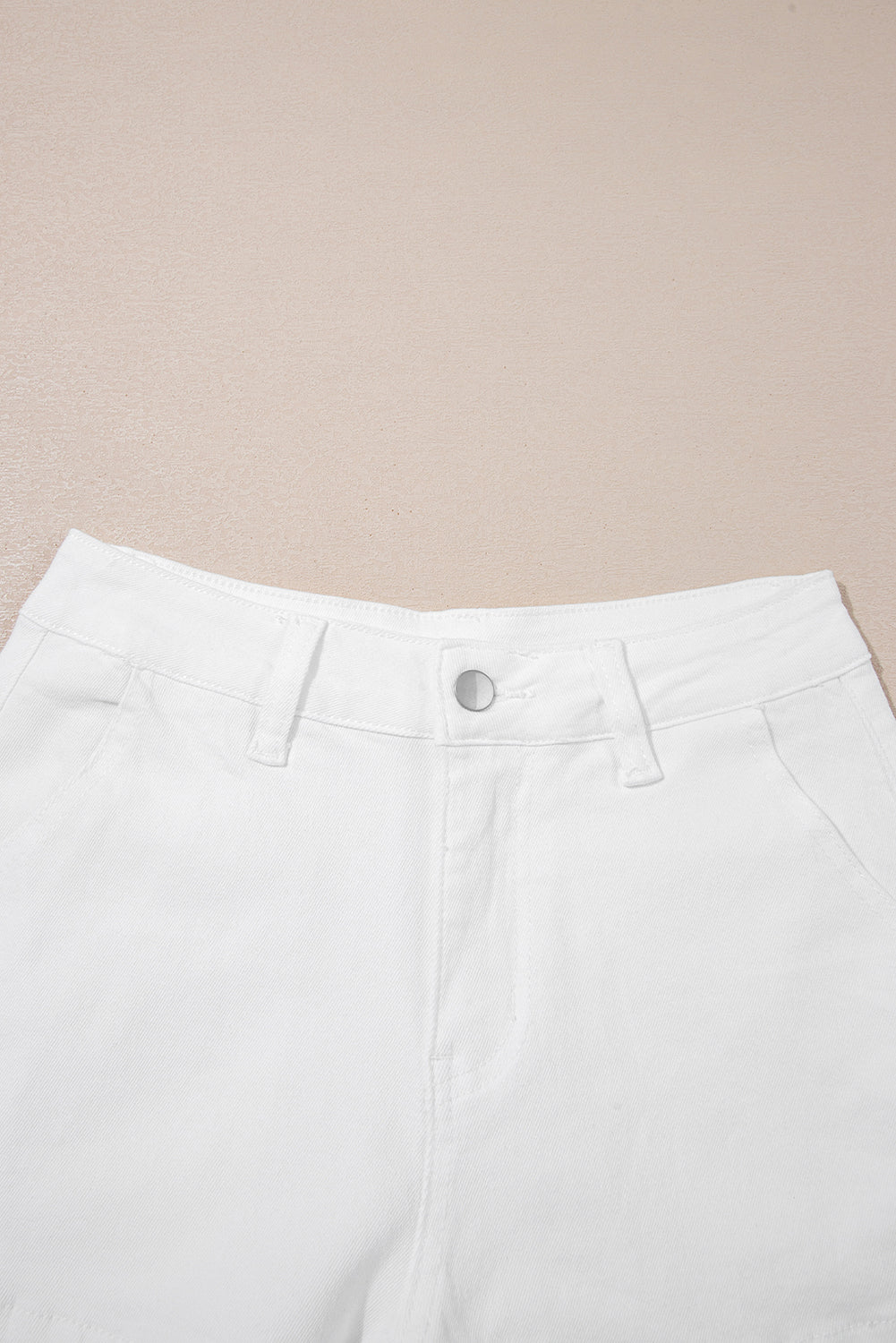 Shorts de denim blanco lavado claro con dobladillo ondulado