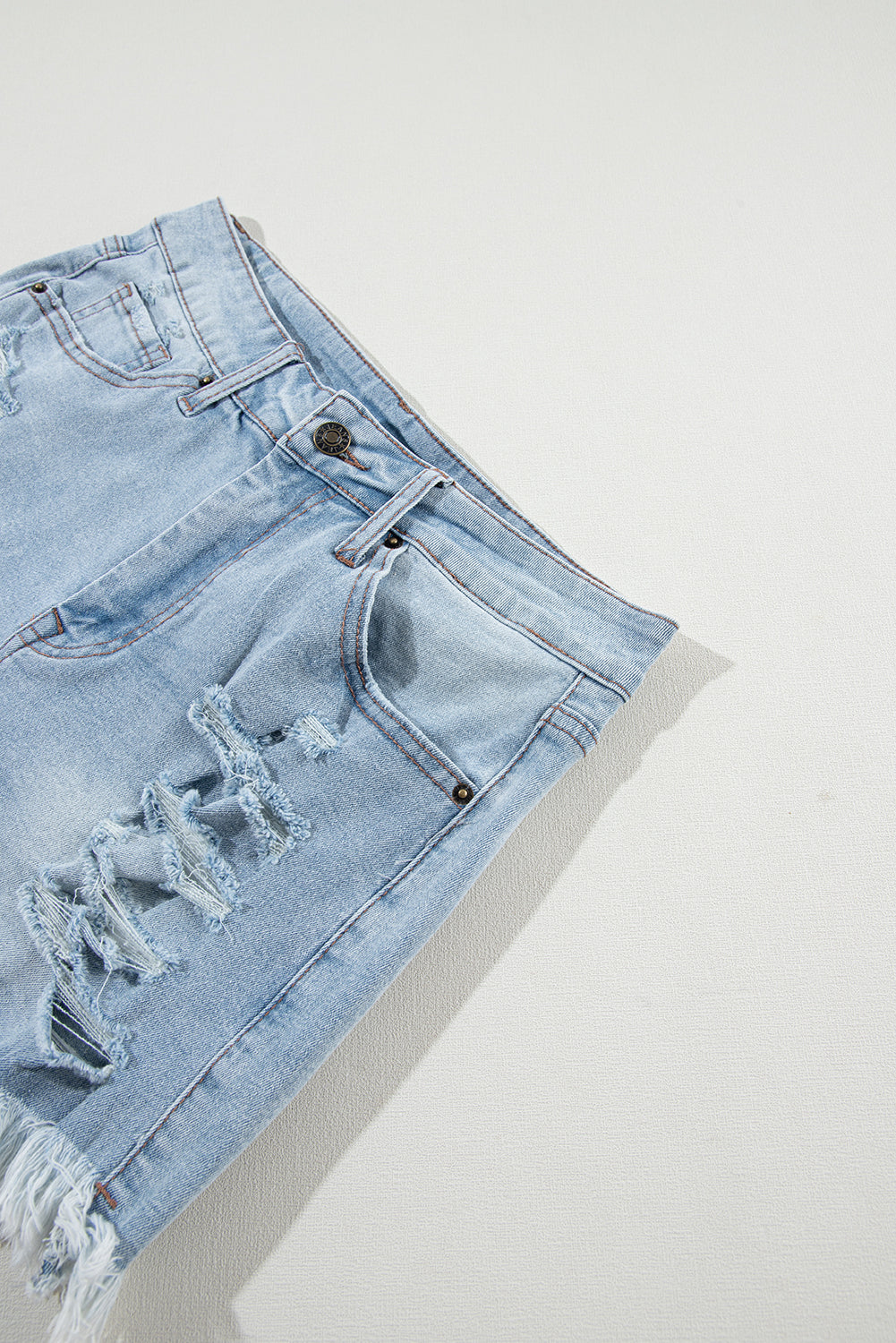 Shorts de denim azul claro desgastados con roturas, tiro alto y dobladillo crudo