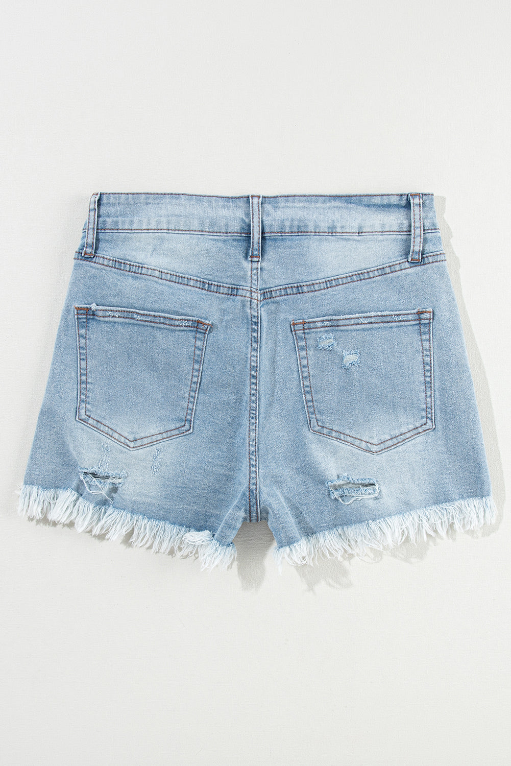 Shorts de denim azul claro desgastados con roturas, tiro alto y dobladillo crudo